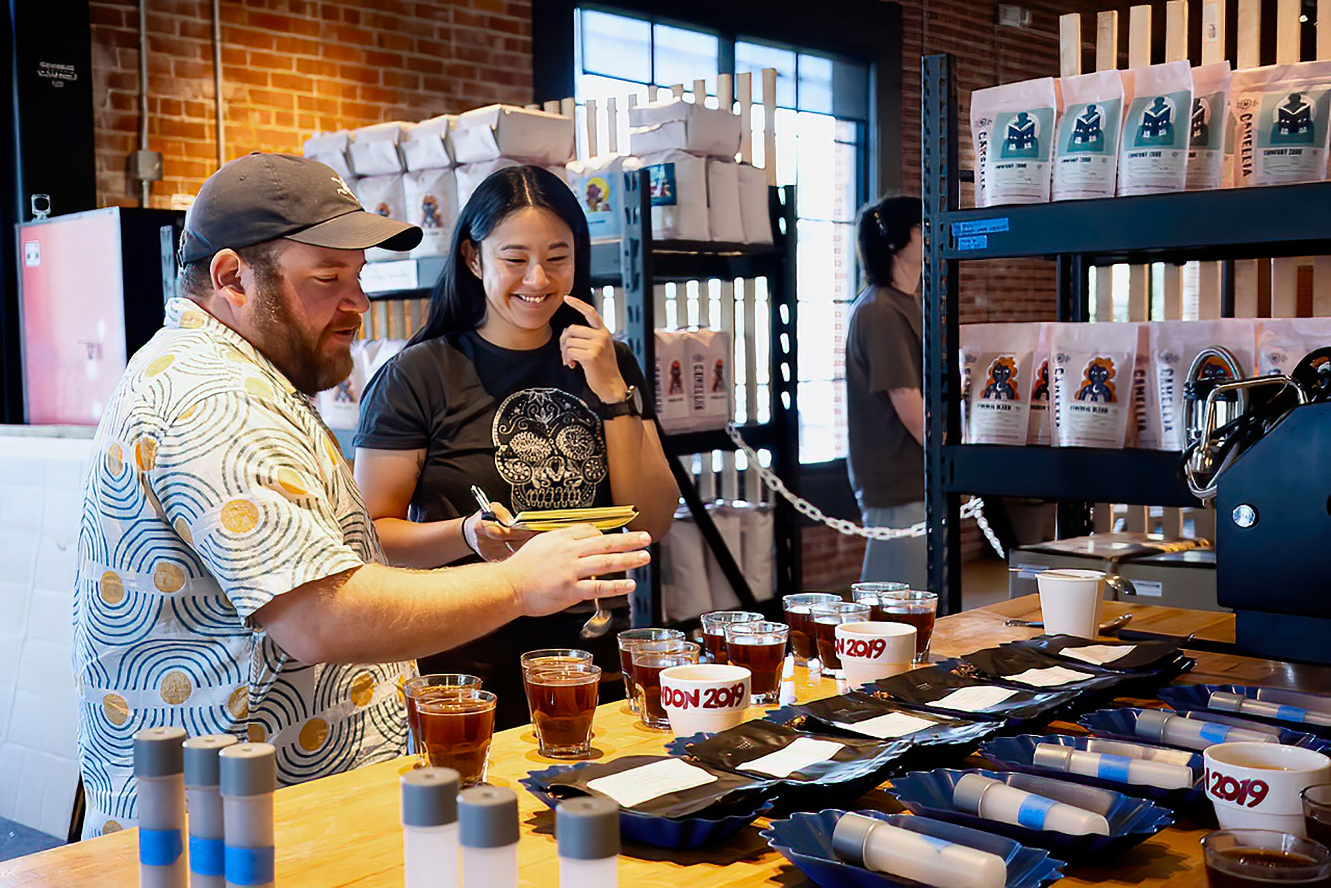 Two people standing at a counter in a Coffee Roasters shop.